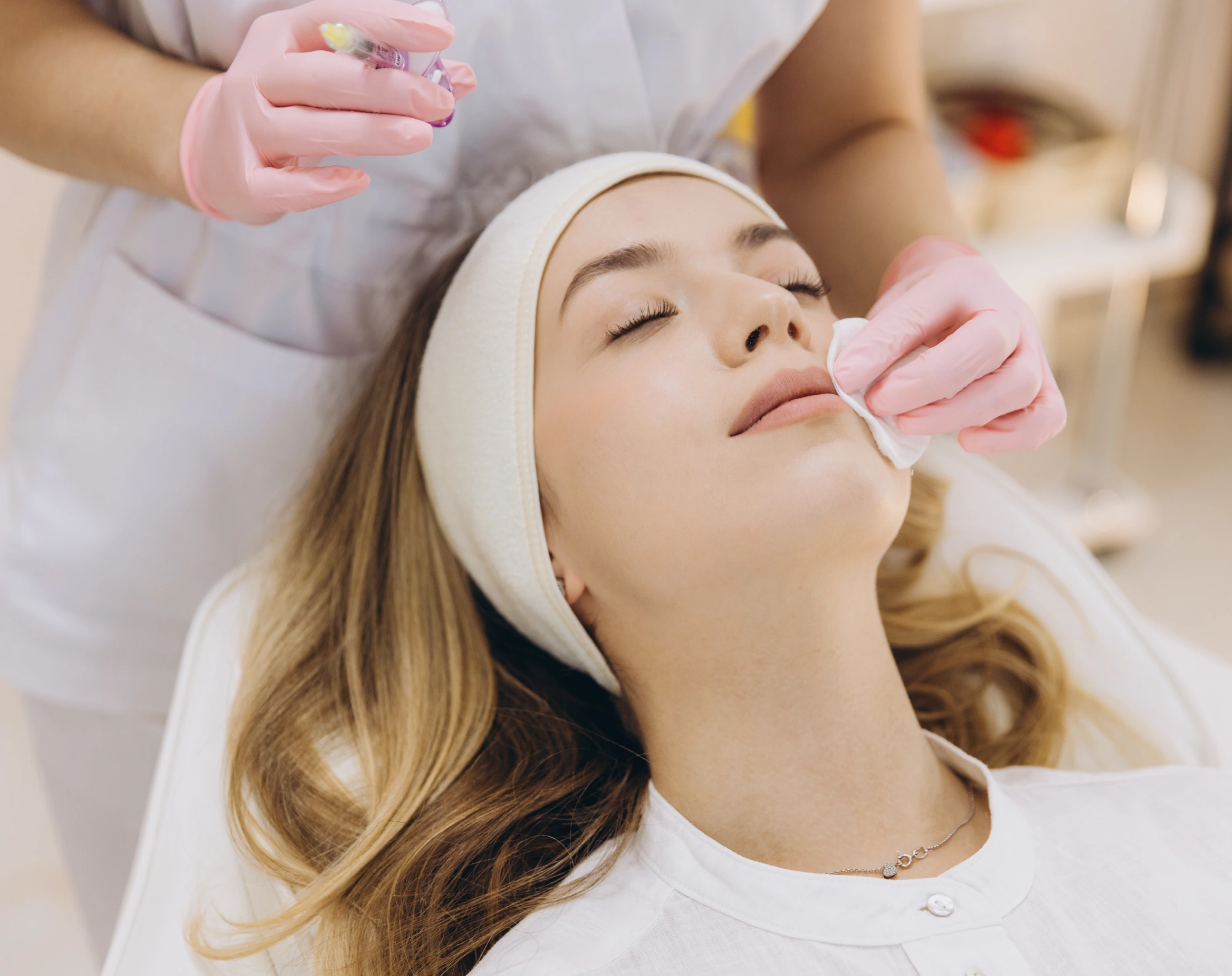Woman receiving facial cleansing treatment