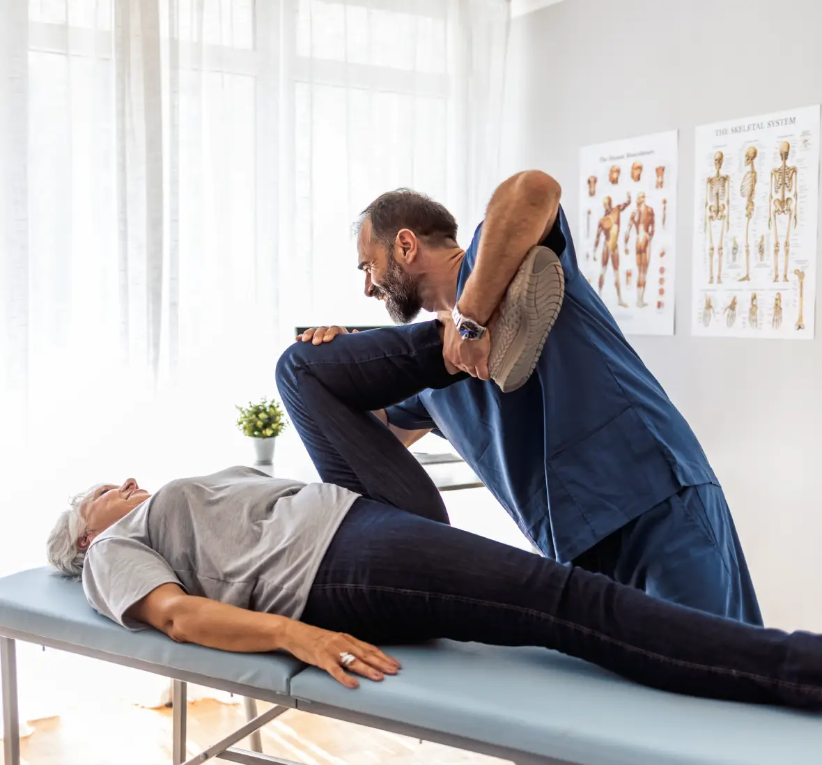 Physiotherapist stretching patient's leg