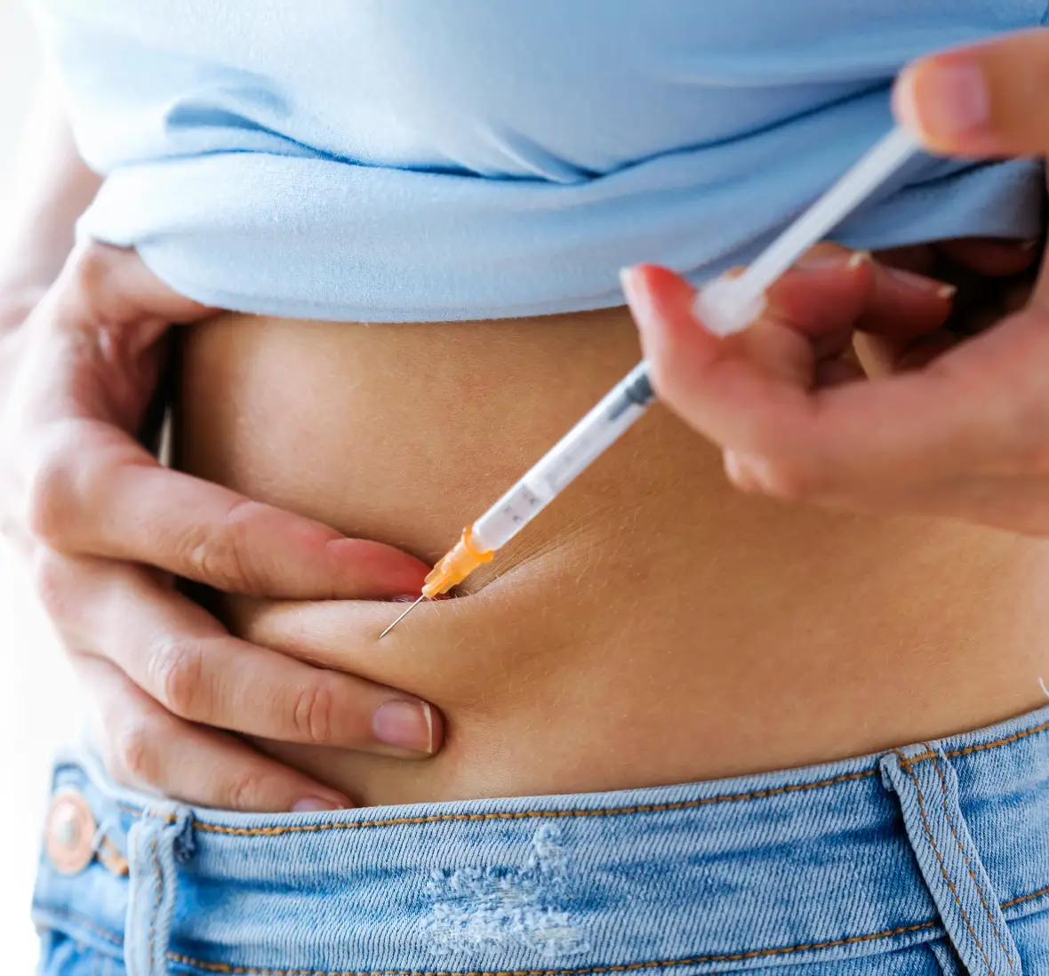 Person administering insulin injection in abdomen