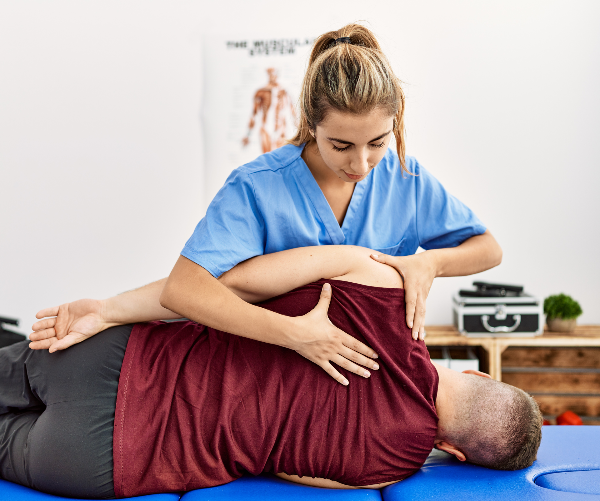 Physical therapist adjusting patient's back