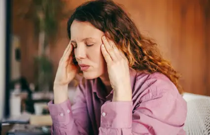 Woman holding head in stress